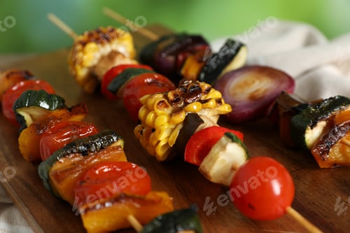Preview: Skewers with tasty grilled vegetables on wooden table against blurred background, closeup