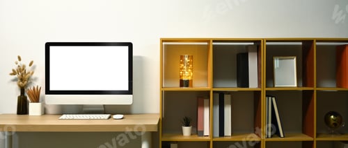 Preview: Blank screen computer desktop, lamp and books on wooden table near bookshelf