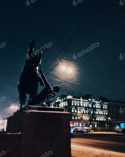 Preview: Ancient monument over night snowy city background. Beautiful city with old bilduings