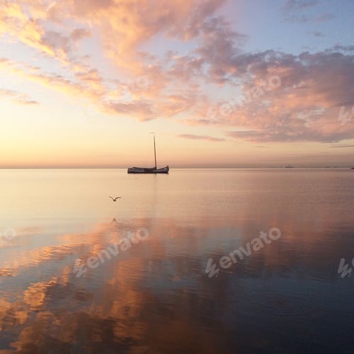 Preview: Sunrise reflection in a lake with a ship anchored in the distance