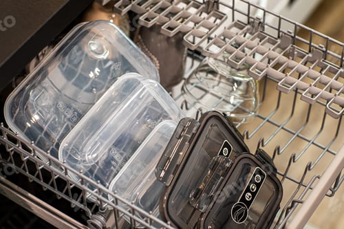 Vista previa: closeup of plastic containers in a dishwasher, in a kitchen indoors
