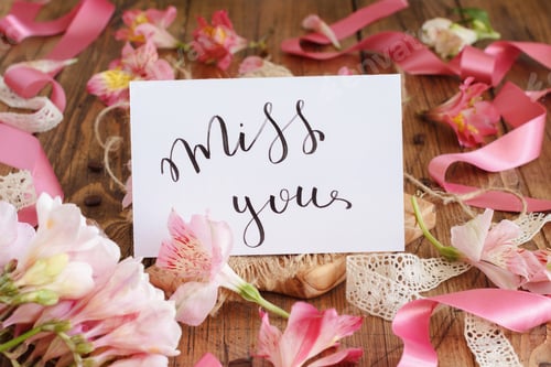 Preview: MISS YOU card on a wooden table between pink flowers