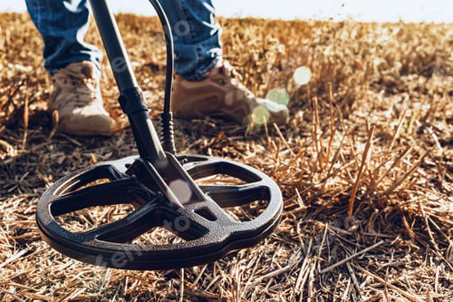 Preview: Man with metal detector equipment searching for metal goods in the field