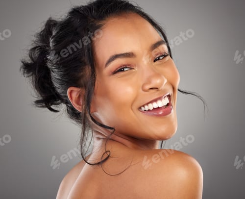 Preview: Cropped portrait of an attractive young woman posing in studio against a grey background
