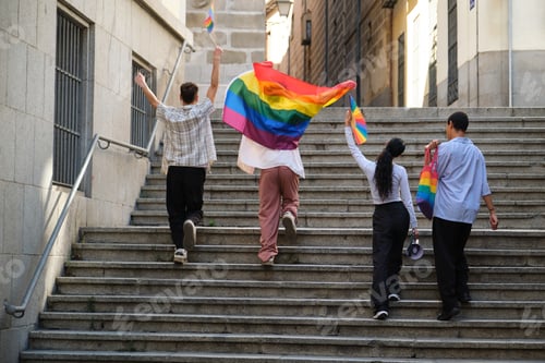 Preview: People walking upstairs holding pride rainbow flags celebrating LGBTQ plus