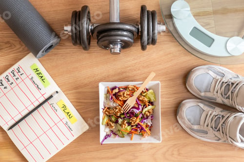 Preview: Directly above view of a wooden table with a healthy salad. Dumbbells.Fitness and balanced nutrition