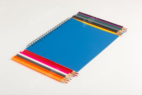 Preview: front view colorful pencils with blue copybook on white background art drawing color paint