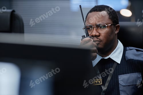 Preview: Middle Aged Black Man Monitoring Security Systems While Using Walkie Talkie