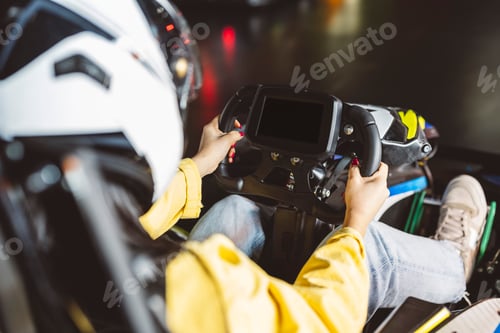 Preview: closeup detail of teenager grabbing the steering wheel of the karts in the race on the asphalt track