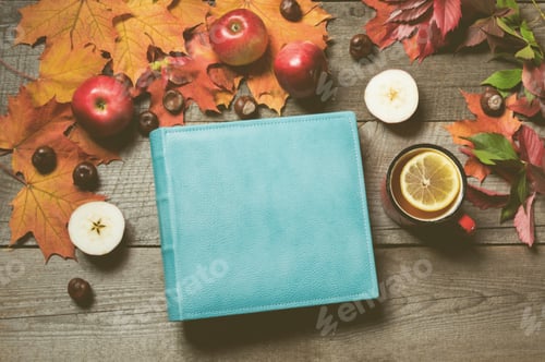 Preview: Fall concept. Vintage album with space for text and cup of tea in hand, decor of autumn leaves