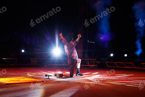 Preview: Clown with a funny hairstyle entertains guests in the circus arena in light of spotlights and smoke