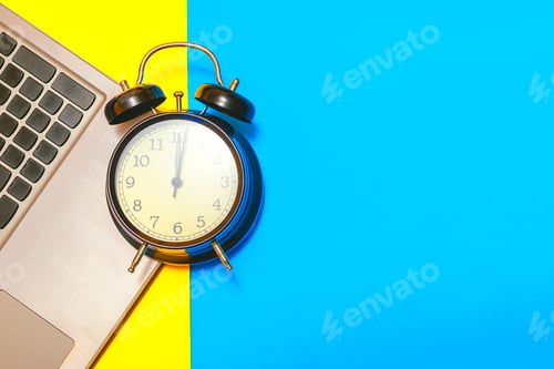 Preview: Concept time to work. Alarm clock with a laptop on a yellow and blue background.