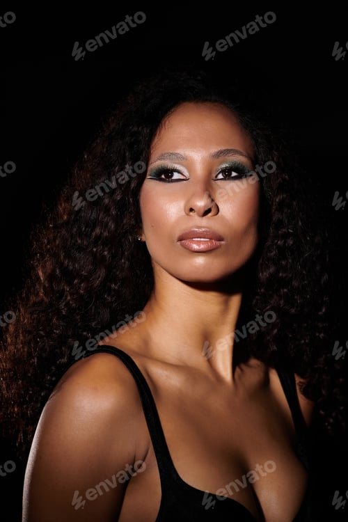 Preview: Elegant beauty with radiant skin and captivating eyes posing against a dark backdrop