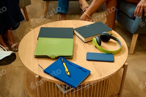 Preview: People meeting casually around coffee table with books