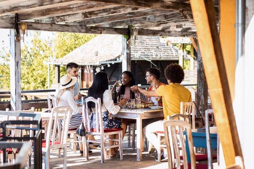 Preview: Group of friends at reunion eating and drinking wine.
