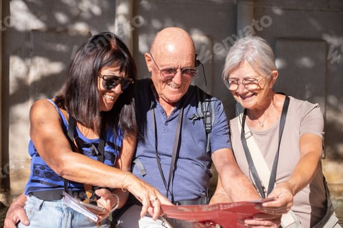 Preview: Joyful group of senior friends visiting Granada listening to information via audio guide