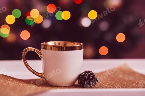 Preview: White cup of tea in front of Christmas tree. Cup mock up with cone. Traditional holidays coziness