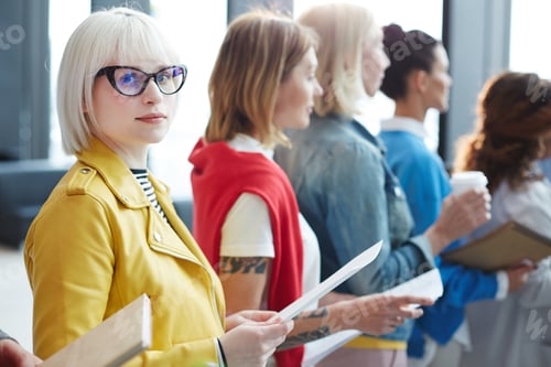 Preview: Blonde girl examining application form in line