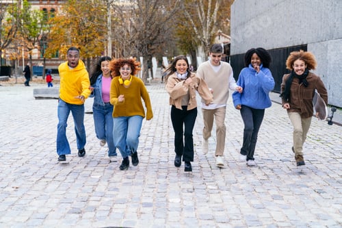 Preview: Multiethnic group of young people running down the street