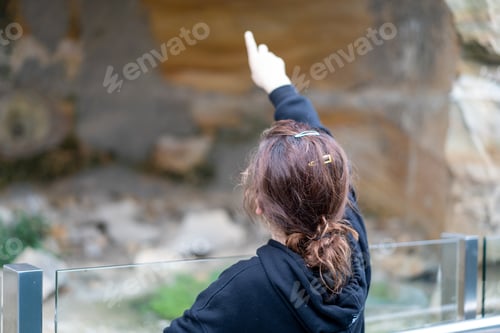 Preview: child pointing to old sand stone cave
