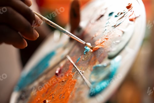 Preview: Painter mixes multiple watercolor paints on a palette to create a new artwork