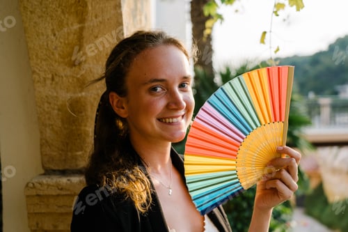 Preview: Smiling woman with colorful umbrella on street