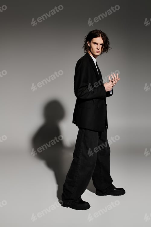Preview: A confident young man in a stylish black outfit and unique hairstyle stands proudly.