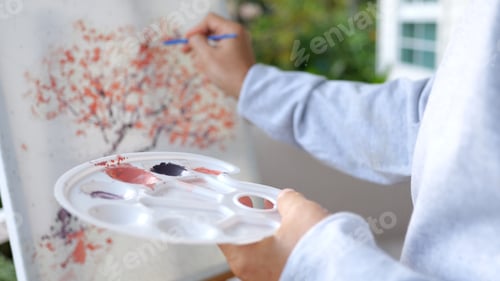 Preview: Senior holding color paint drawing on white paper