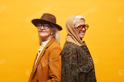Preview: Two happy senior women in stylish apparel posing in front of camera