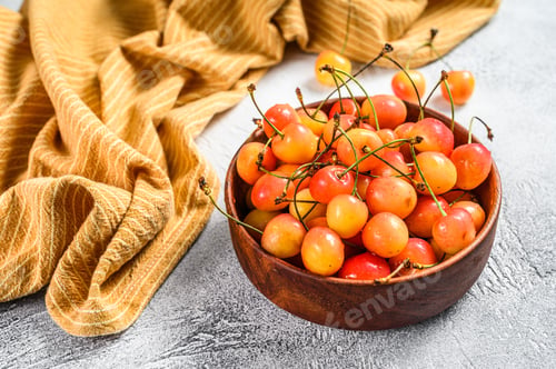 Preview: Yellow ripe cherries in a bowl. White background. Top view