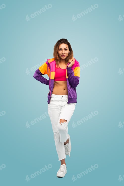 Preview: Trendy young lady standing in studio with hand on waist