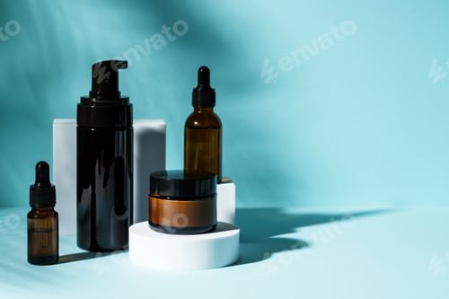Preview: Cosmetic products at podium on blue background.