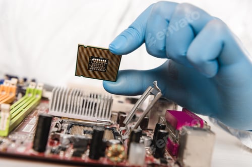 Preview: cropped view of microchip in hand of scientist near motherboard