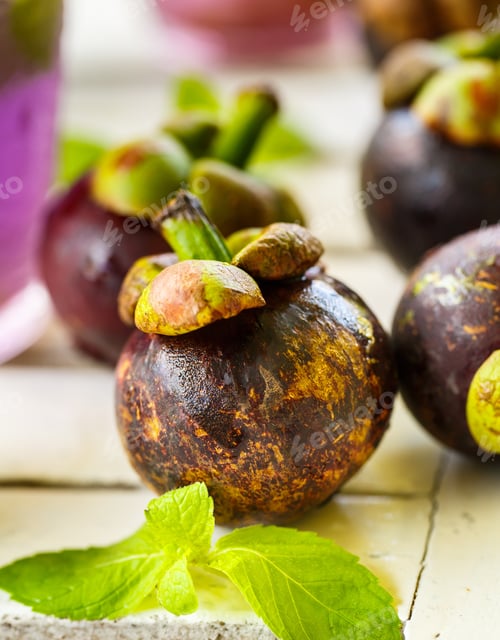 Preview: Mangosteen with mint leaves on a white table
