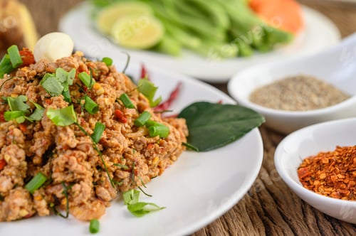 Preview: Spicy Minced Pork Salad on a white plate with red onion, lemon grass, garlic, yardlong beans.