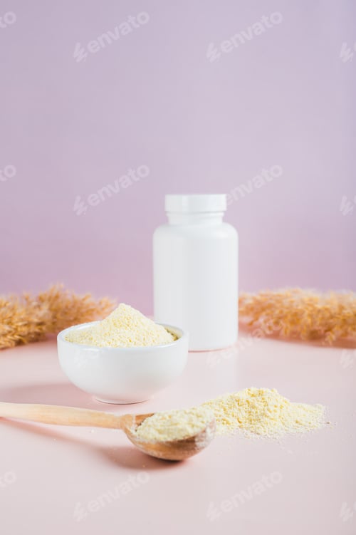 Preview: Collagen powder in a bowl and spoon and a glass of water on the table vertical view