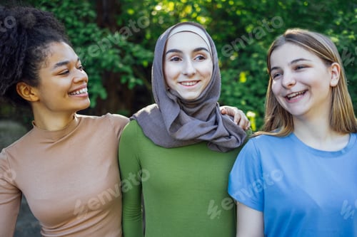 Preview: Multiracial young teen female friends walking in the park laughing