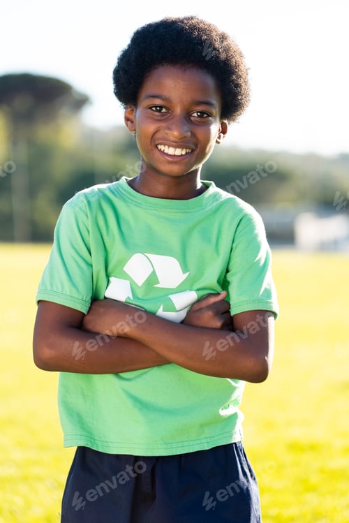 Preview: Portrait of african american schoolboy smiling in recycling tshirt on field at elementary school