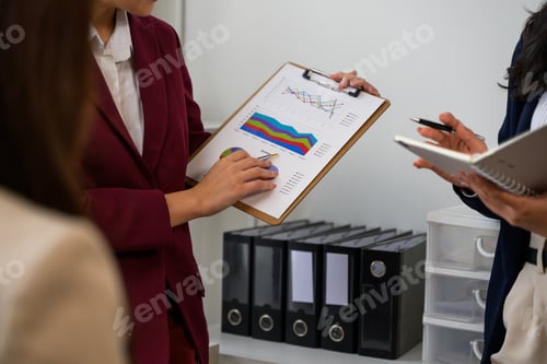 Preview: Businesswomen analyzing financial charts and graphs during office meeting