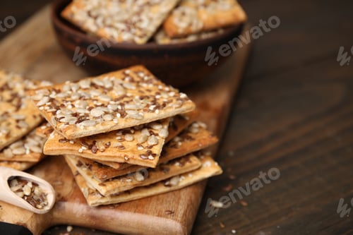 Preview: Cereal crackers with flax, sunflower and sesame seeds on wooden table, closeup. Space for text