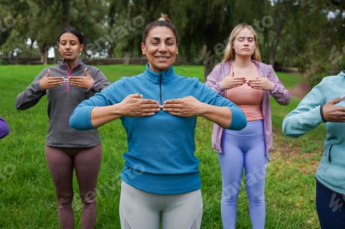 Preview: Multiracial women doing yoga exercise for good body posture at city park