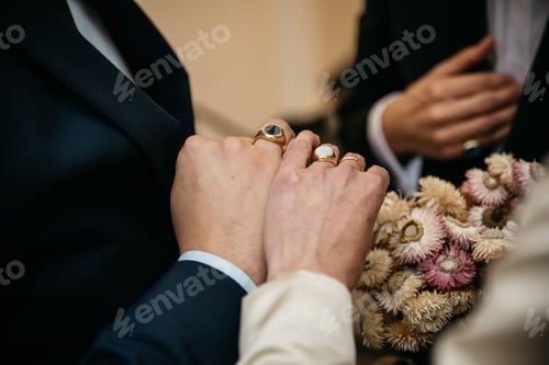 Preview: Close-up of a couple's hands featuring their wedding rings