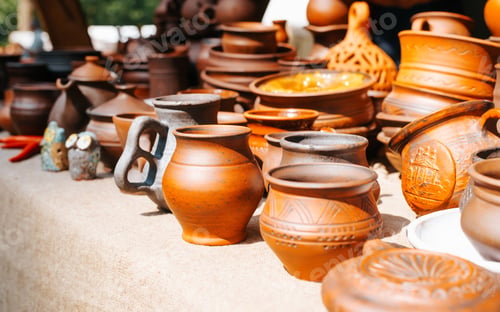 Preview: Side view of craft clay pottery, handmade ceramic mugs pots in medieval rustic style outdoors