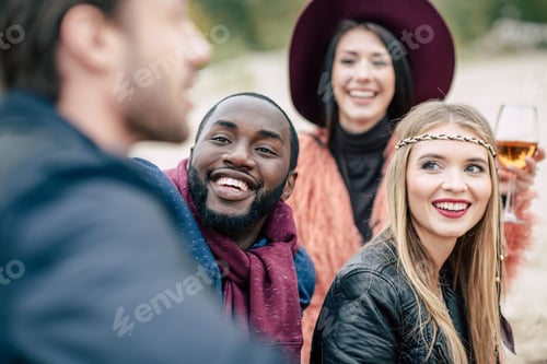 Preview: Close-up view of happy young friends looking at blurred man on foreground