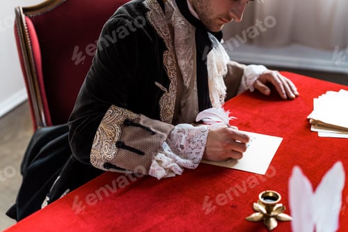Preview: cropped view of victorian man holding feather and writing letter