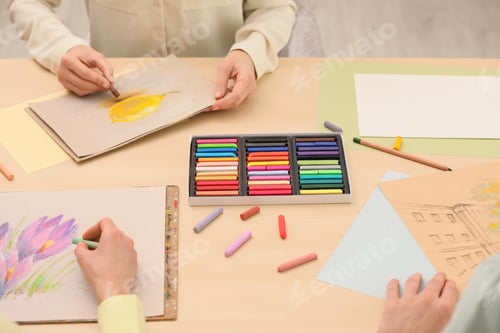Preview: Artists drawing with soft pastels at table, closeup