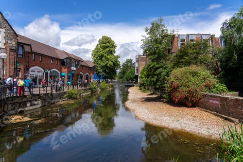 Preview: Scenic view of a river with pedestrians walking along a riverside path in Winchester, UK