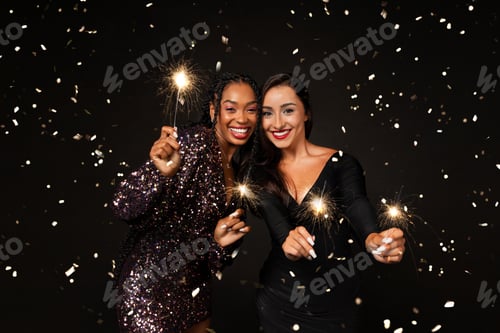 Preview: Happy multiethnic girlfriends celebrating New Year 2024 together, holding bengal lights