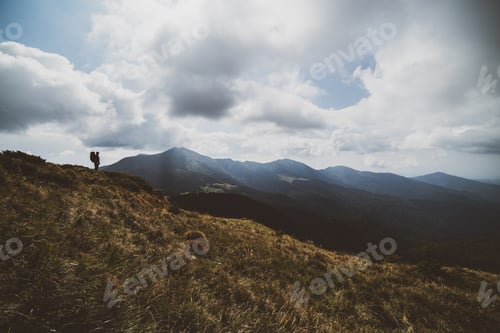 Preview: The man standing on the mountain on a cloud background