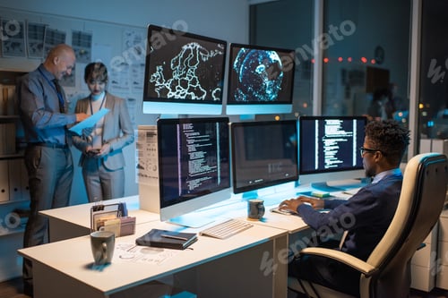 Preview: Young African businessman looking at data on computer screen